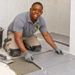 Artisan installing bathroom floor tiles