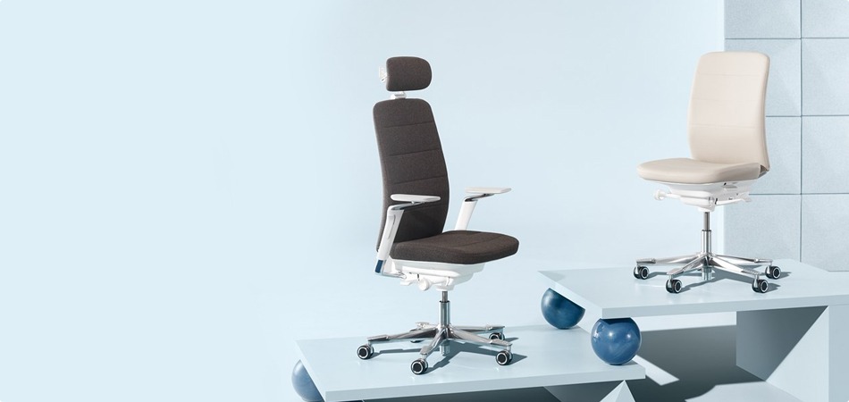 Two adjustable office chairs, dark brown and light beige, on elevated geometric platforms against a pale blue wall.